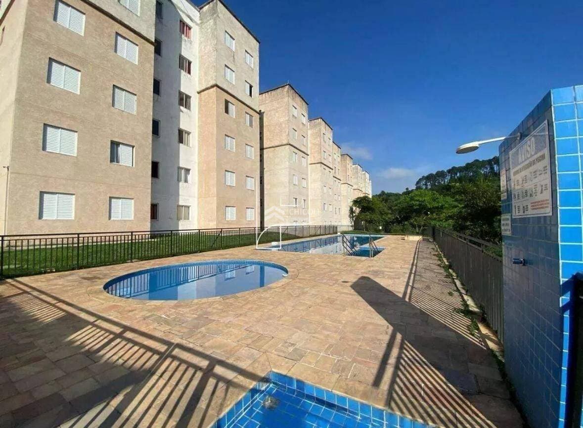 Piscinas em área comum com prédio de múltiplos andares ao fundo.