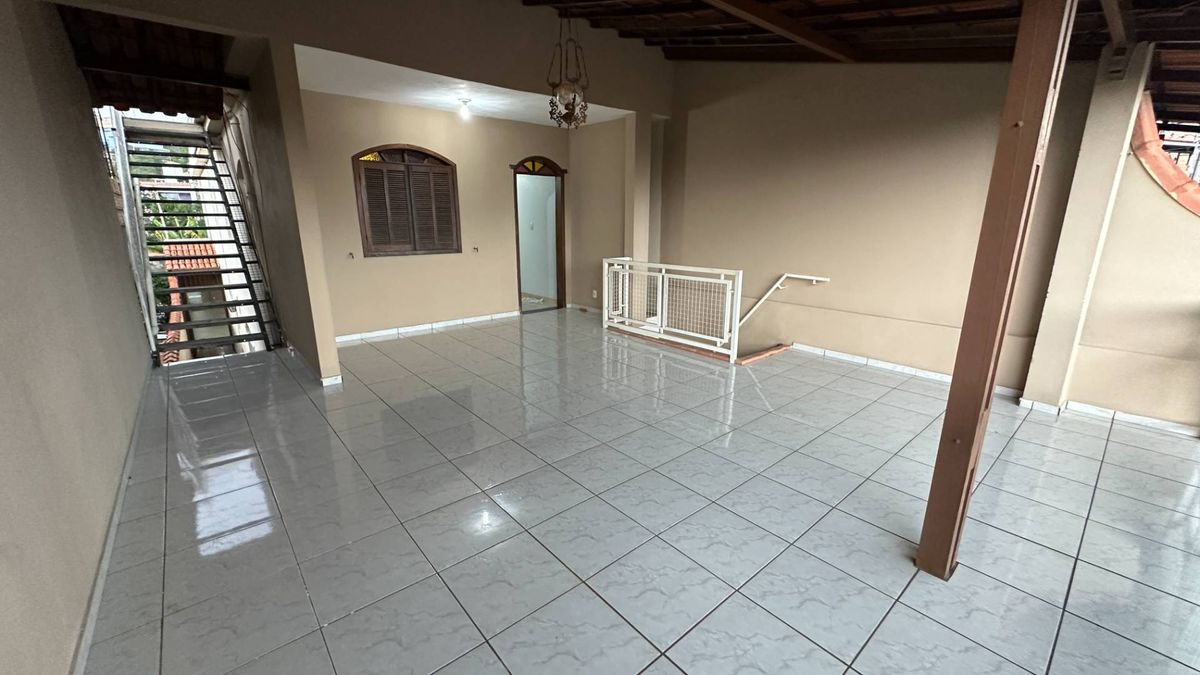 Sala com teto de madeira, paredes bege e piso de azulejo branco