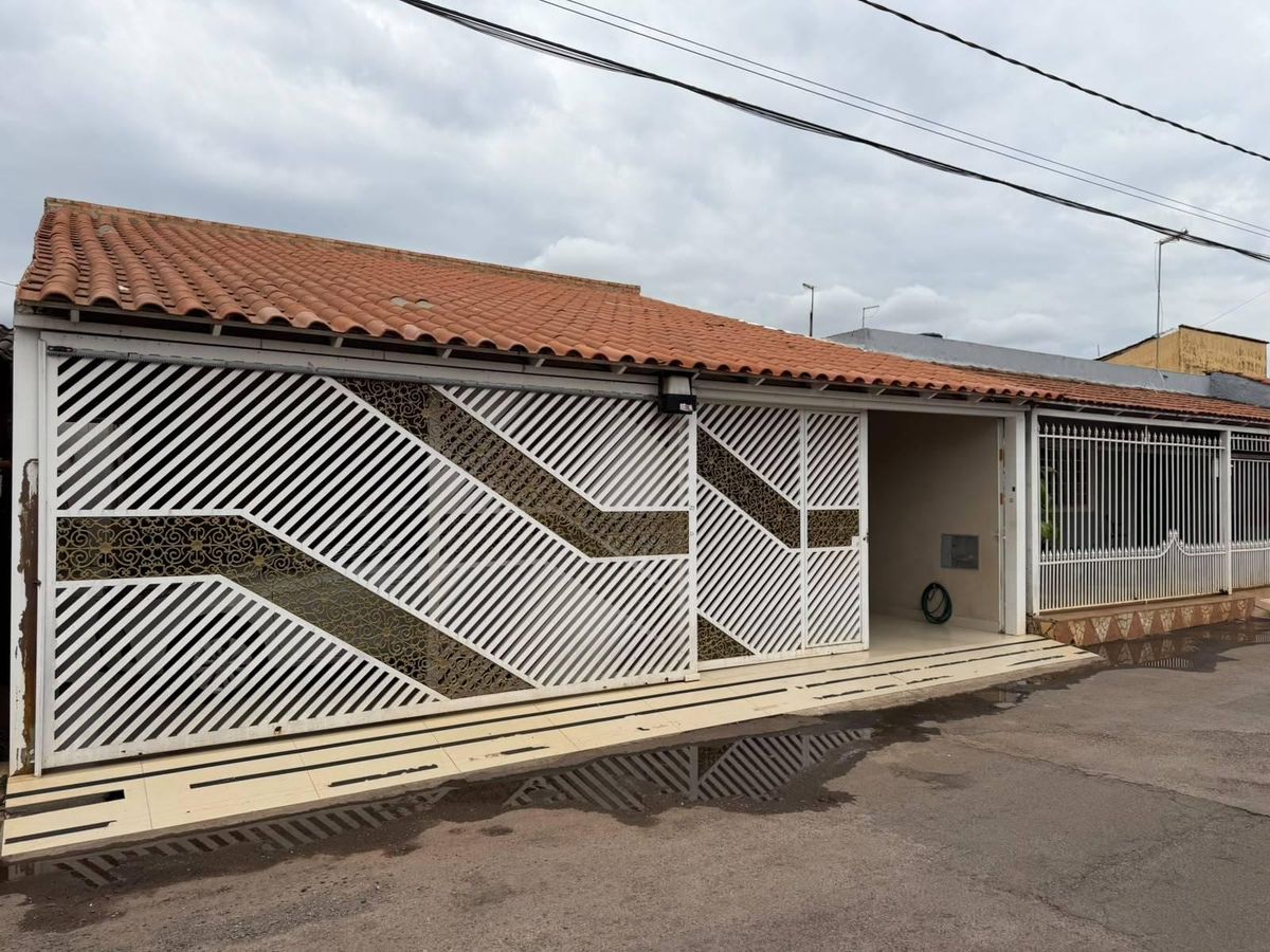 Fachada de casa com portão branco e telhado de cerâmica clay
