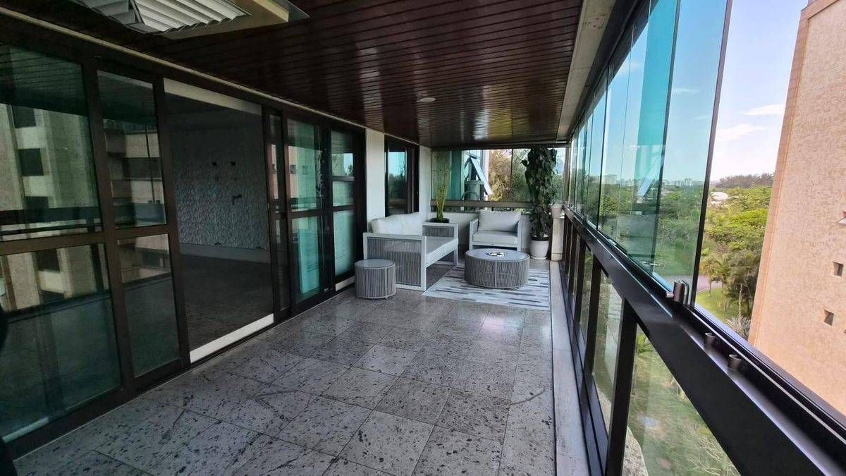 Varanda com piso de granito, móveis brancos e vista para a natureza