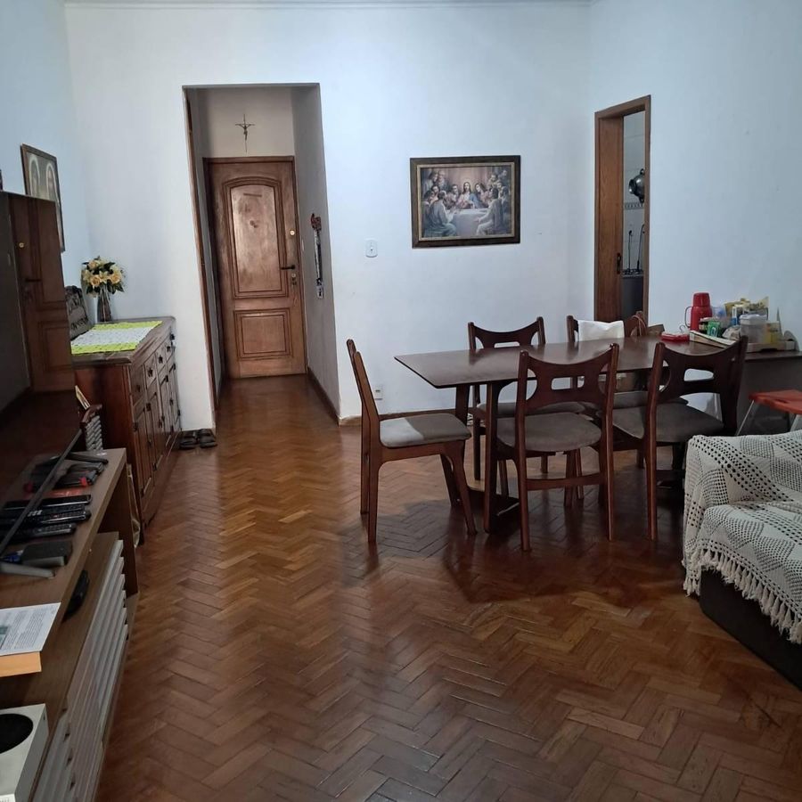 Sala de jantar com piso de parquet, paredes brancas, mobiliário clássico.