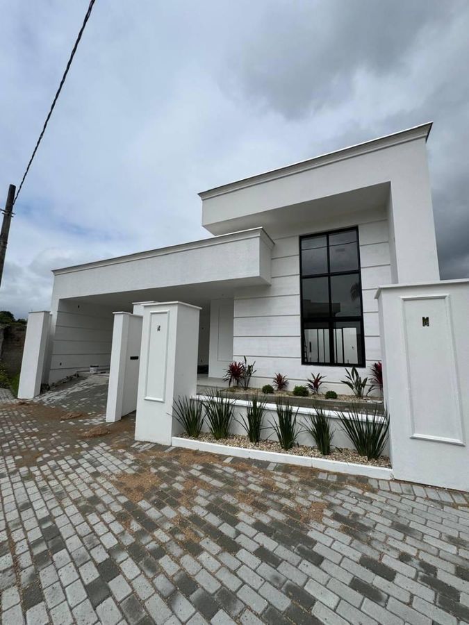 Fachada moderna branca com janelas grandes e jardim na frente