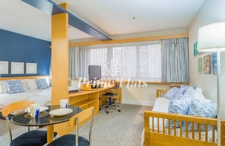 Sala com janela grande, móveis de madeira e revestimento claro