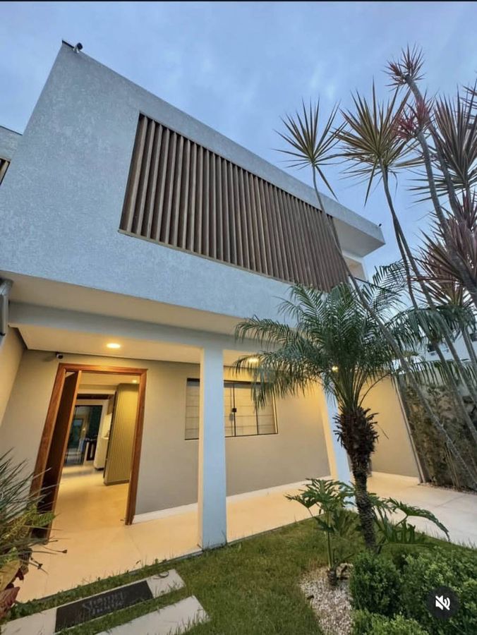 Fachada de casa moderna com área de jardim e toldo na varanda