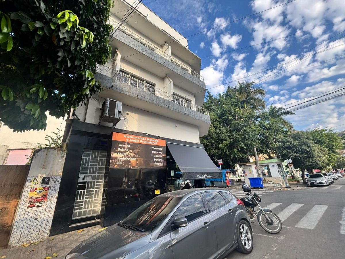 Fachada de edifício com loja de instrumentos musicais, árvores e céu claro