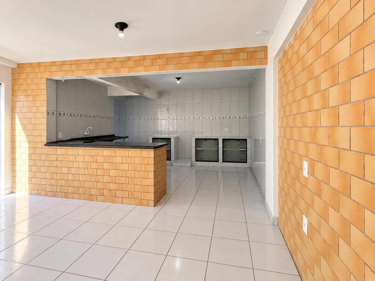 Cozinha integrada com paredes de tijolos à vista, piso cerâmico branco