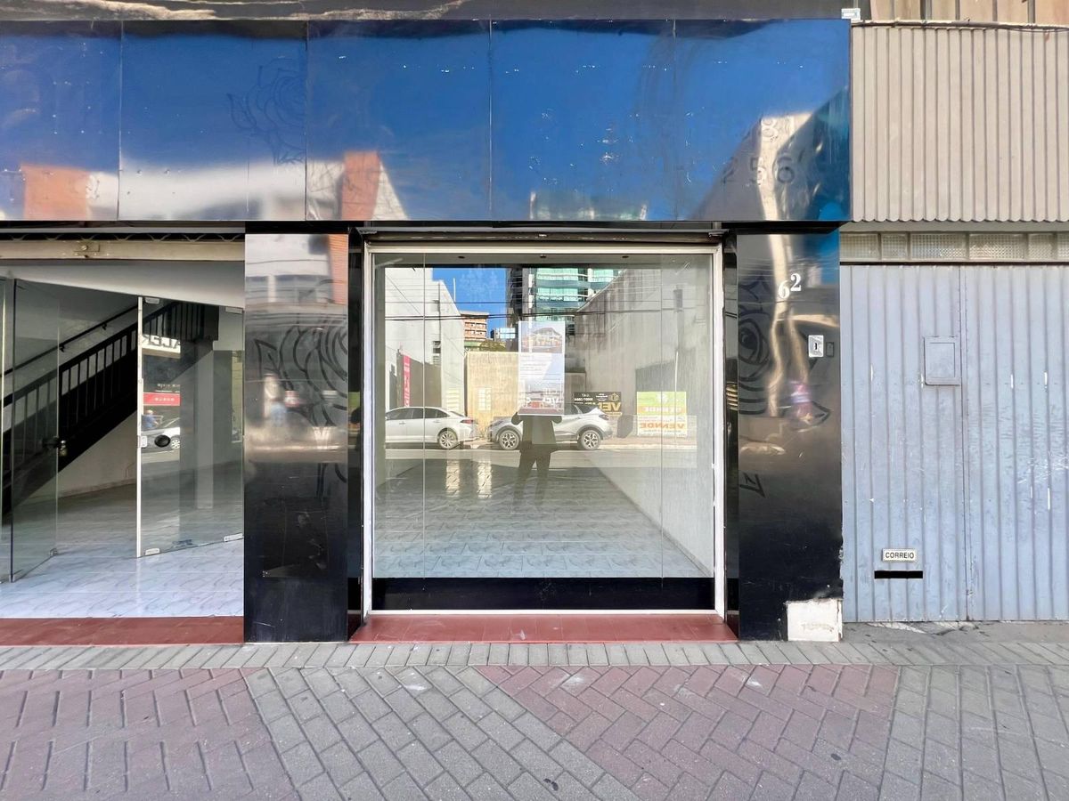 Fachada de edifício comercial com porta de vidro e paredes de metal.