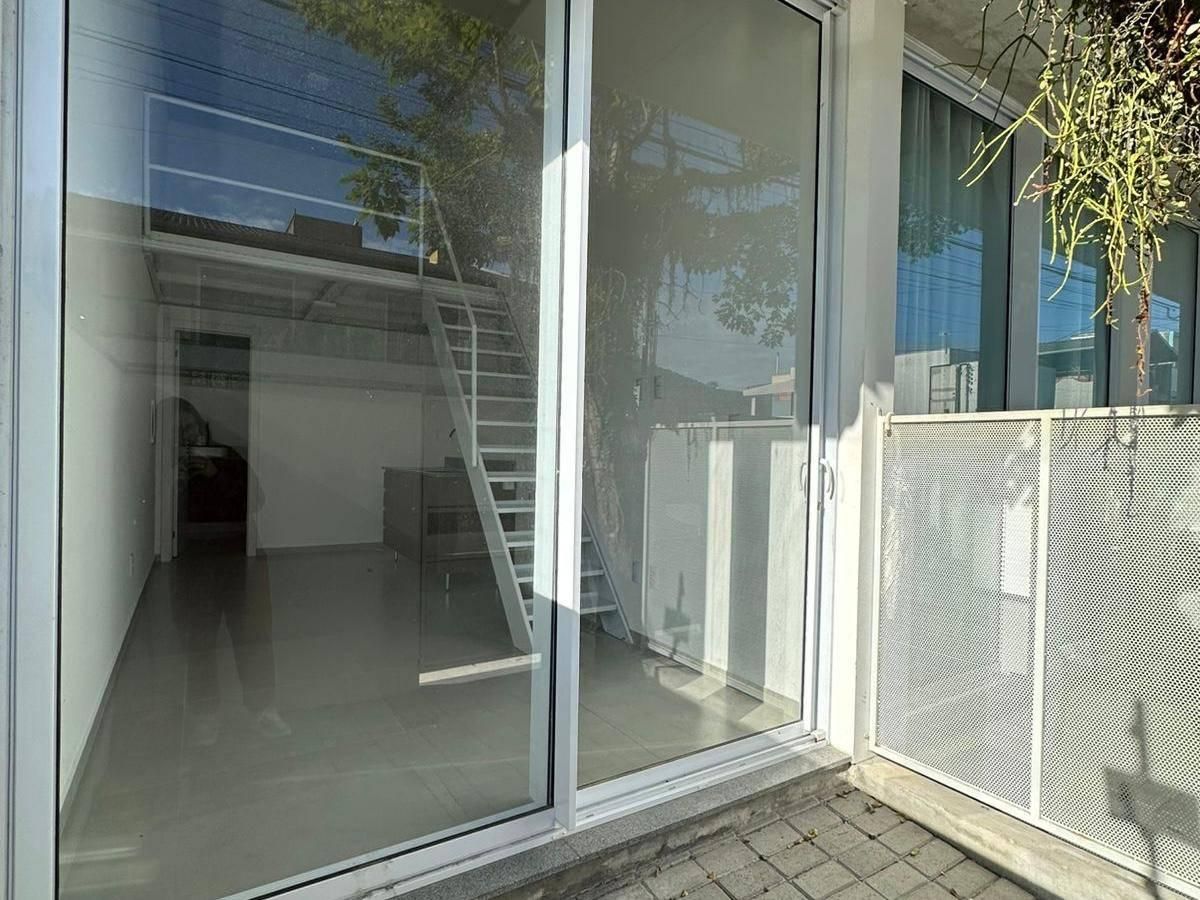 Sala com piso de cerâmica, parede branca, espaço de convívio aberto