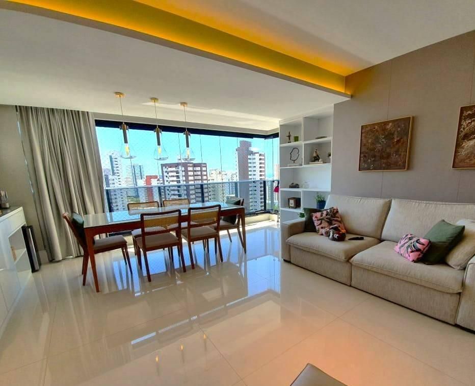 Sala com teto de iluminação embutida, vista para edifícios.