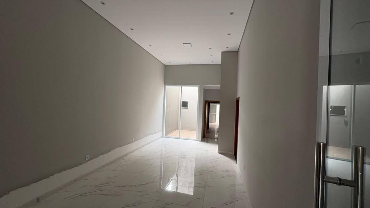 Sala com paredes brancas e piso de mármore, iluminação natural
