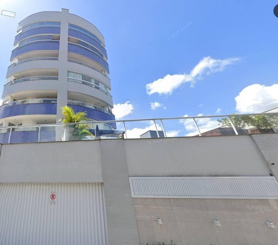 Fachada de edifício residencial com paredes brancas, detalhes em azul e vidro