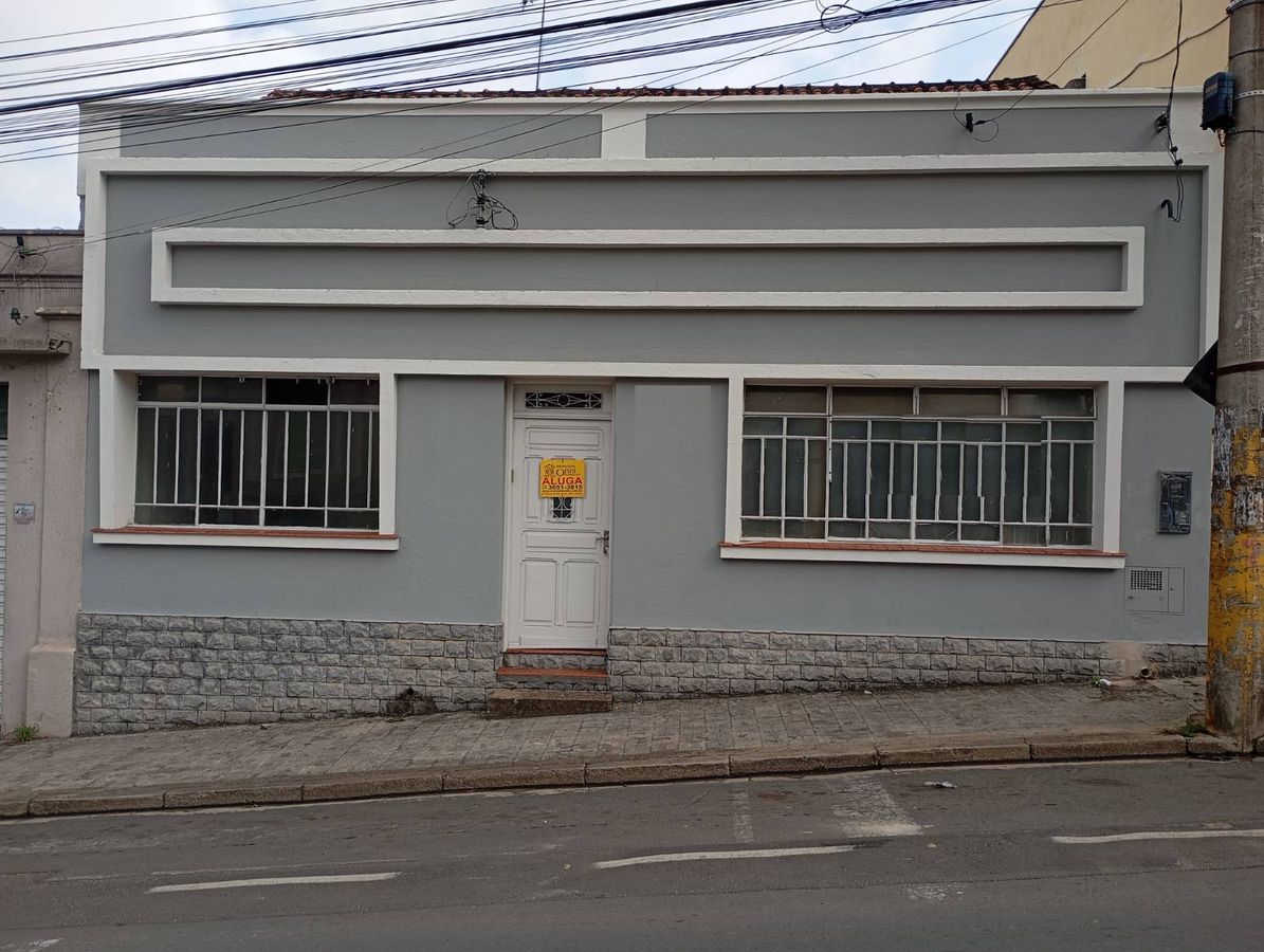 fachada de casa com paredes cinza, janelas de grades brancas