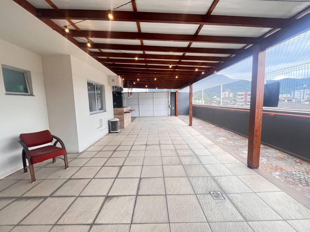 Varanda ampla com piso de cerâmica, teto de madeira, varanda de vidro.