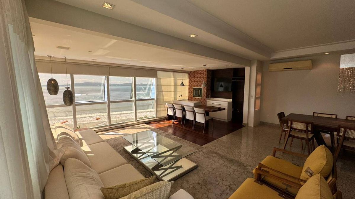 Sala de estar com vista para o mar e janelas grandes