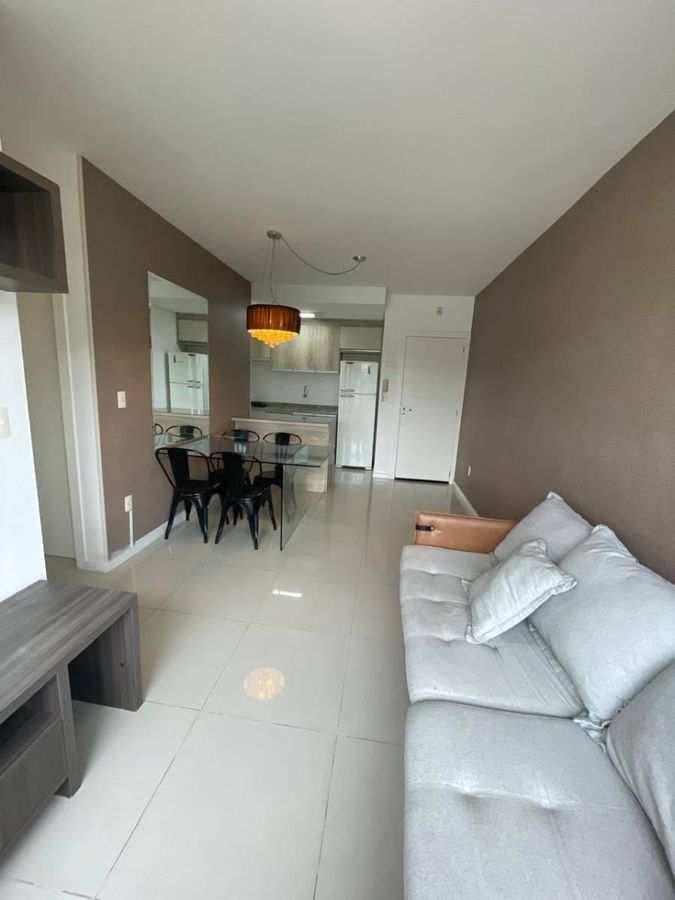 Sala com revestimento liso, parede colorida e móveis modernos