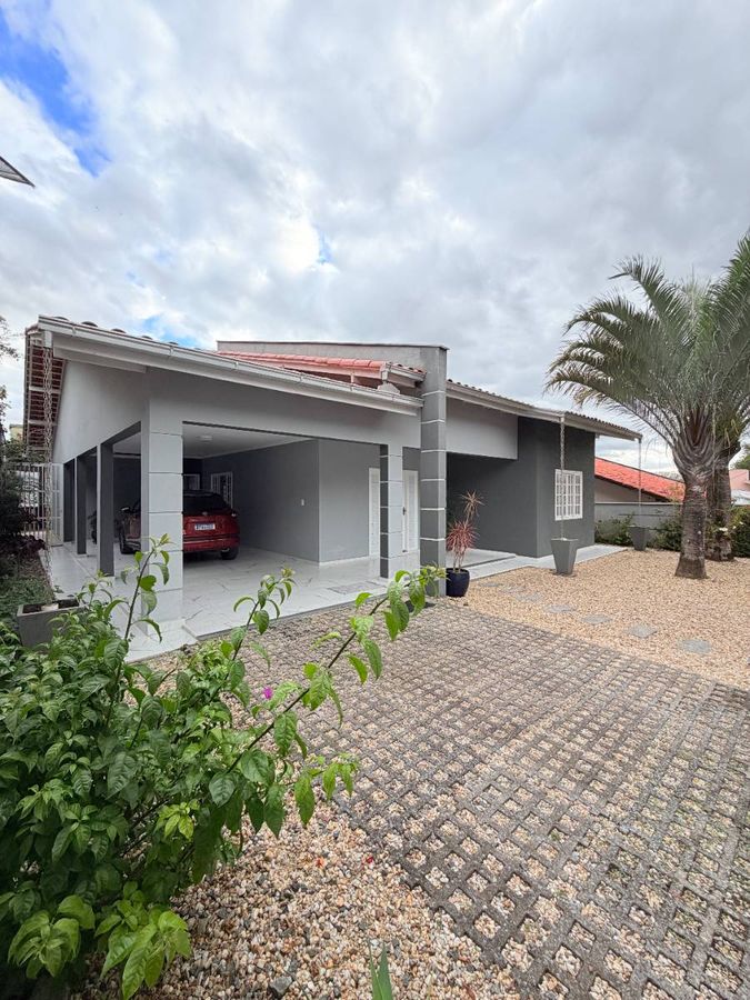 Casa moderna com garagem coberta e jardim na frente