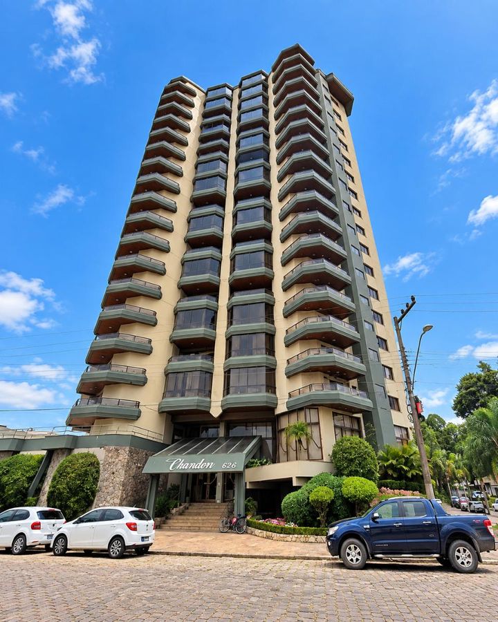 Prédio residencial de concreto com janelas de vidro e varandas em verticais.