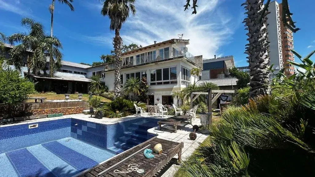 Foto principal da área externa da casa com piscina
