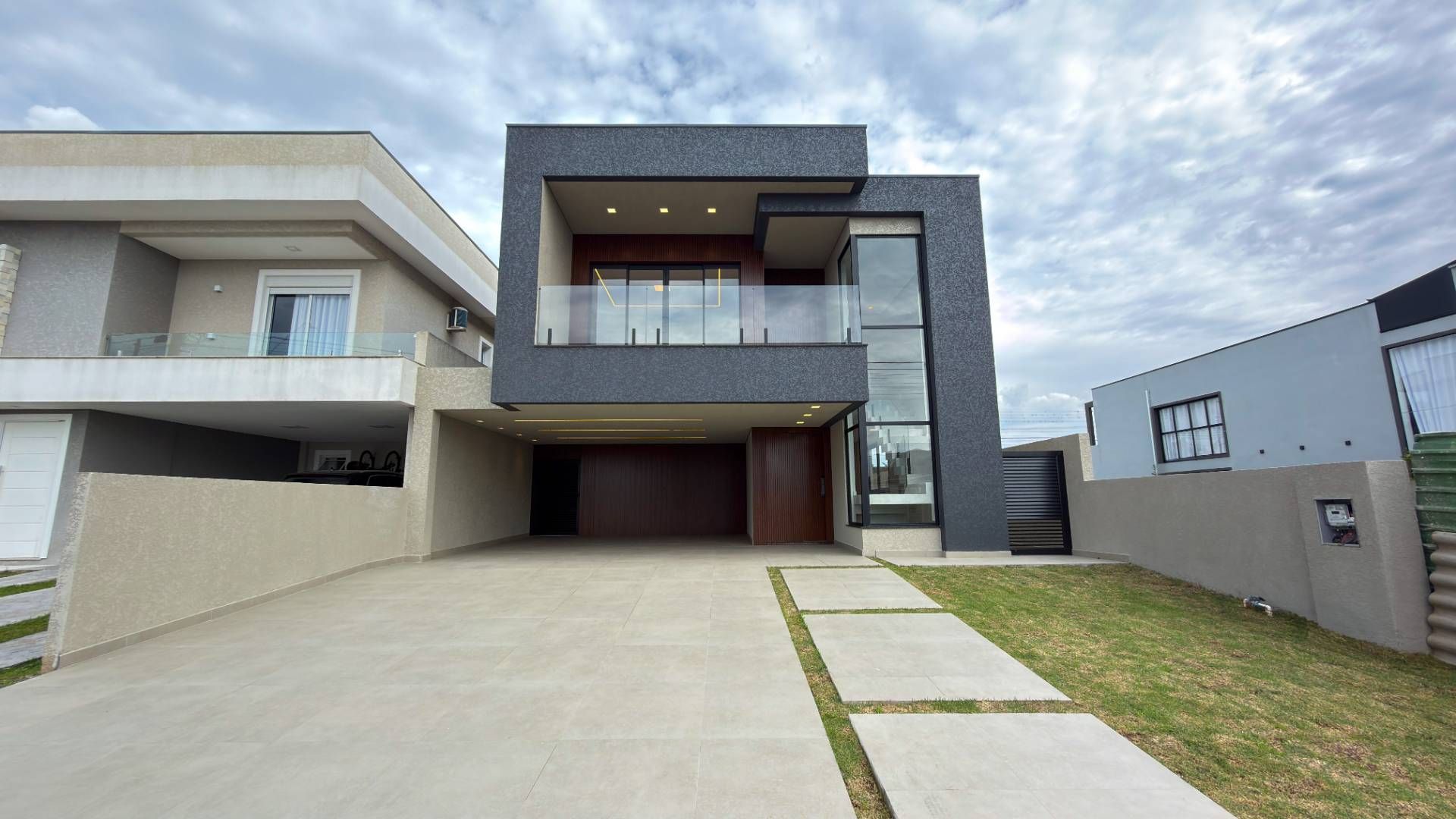 Fachada moderna de residência com uso de cores cinza e detalhes em madeira