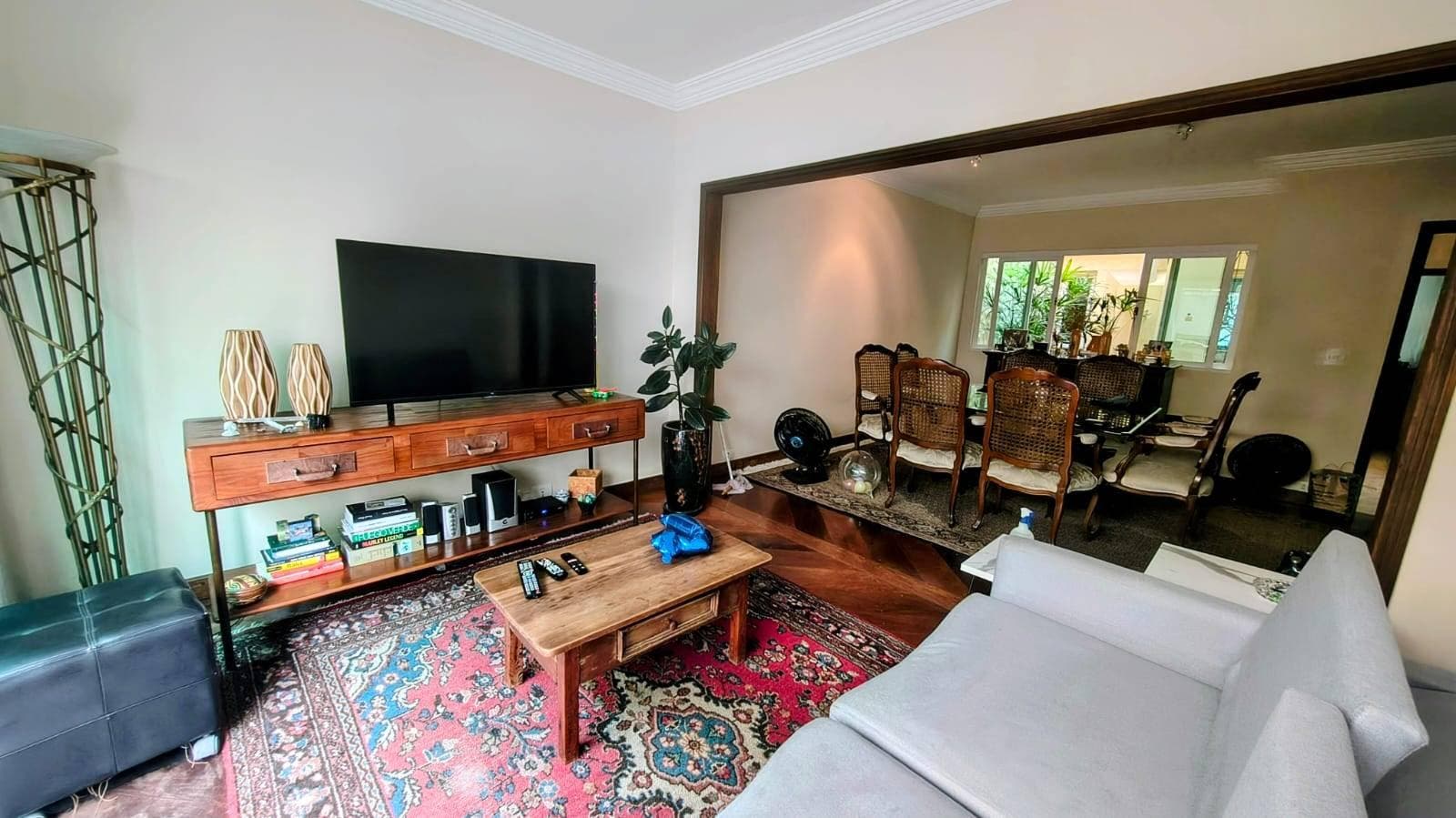 Sala de estar com poltrona, mesa de centro, sofá e TV