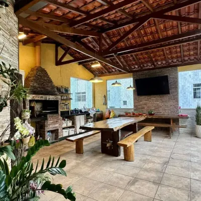 Escritório com paredes de pedra, teto de madeira e plantas decorativas.