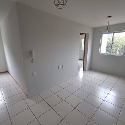 Sala com acabamento em tinta branca, piso de porcelanato, janelas grandes