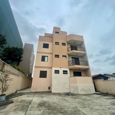 Edifício de várias alturas com fachada em tons de bege e detalhes pretos