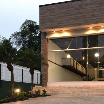 Fachada de prédio comercial com vidro e iluminação externa, noite