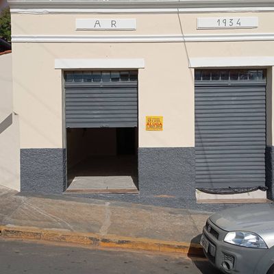 fachada de prédio com duas portas de metal, pintura clara e detalhes cinza