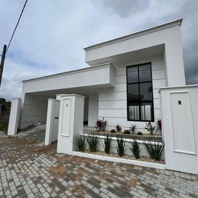 Fachada moderna branca com janelas grandes e jardim na frente