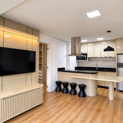 Cozinha moderna com armários bege, ilha e iluminação embutida