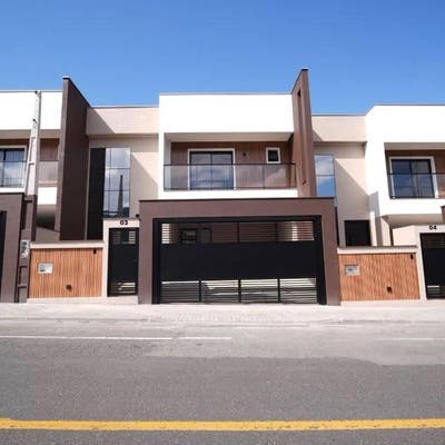 Fachada de prédio residencial moderna com garagem e varanda, dia claro.