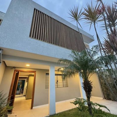 Fachada de casa moderna com área de jardim e toldo na varanda