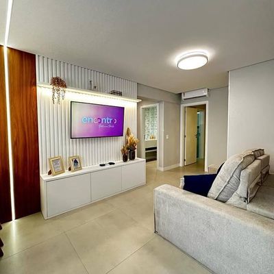 Sala com paredes de revestimento branco e painel para TV