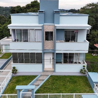 Edifício de três andares com fachada azul e detalhes em pedra