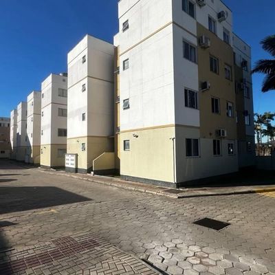 Prédio de apartamentos em área de estacionamento com calçada pavimentada