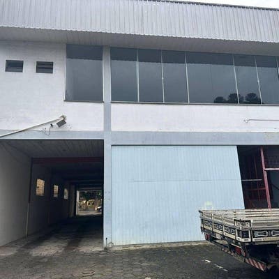 Prédio de três andares com garagem e varanda frontais de vidro