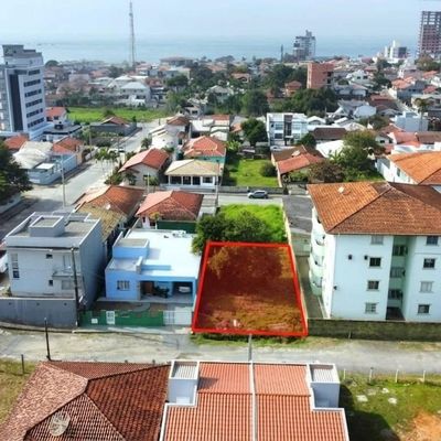 Área de terreno vazia entre casas com vegetação e grama
