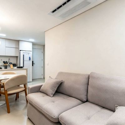 Sala integrada com cozinha, iluminação direta, acabamento branco fosco