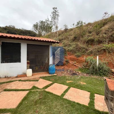 Casa com jardim e morro ao fundo