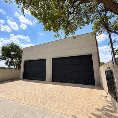 Edifício de fachada com portas de metal preto e piso de telha intertravada