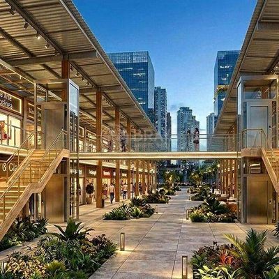 Ambiente de shopping ao ar livre, com lojas e escadas de madeira.
