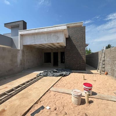 Fachada de construção residencial com paredes de concreto e acabamento em andamento