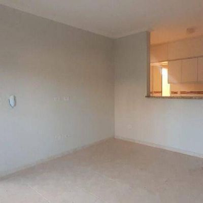 Sala com cozinha integrada, paredes brancas, piso claro e iluminação natural