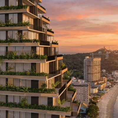 Edifício moderno com varandas verdes, vista para o mar ao pôr do sol