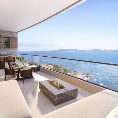 Varanda com vista para o mar e mobília moderna de acabamento em mármore.