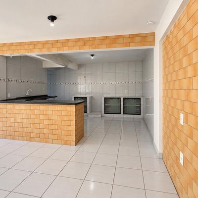 Cozinha integrada com paredes de tijolos à vista, piso cerâmico branco