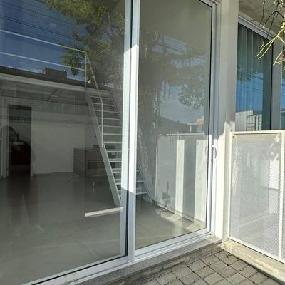 Sala com piso de cerâmica, parede branca, espaço de convívio aberto