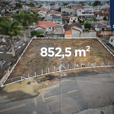 Lote vazio cercado por rua e casas residenciais, área de 852,5 m².