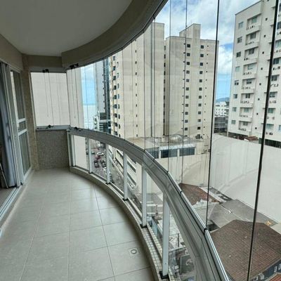 Varanda com piso de cerâmica, vista de prédios residenciais.